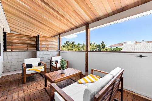 a porch with a couch and a table on a balcony at The Hideaway Hotel in Long Beach