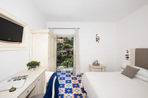 a hotel room with two beds and a window at Hotel Savoia in Positano
