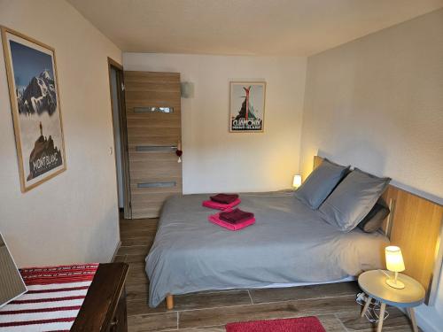 sypialnia z łóżkiem z czerwonymi ręcznikami w obiekcie Appartement hyper centre 6 pers. w Chamonix-Mont-Blanc