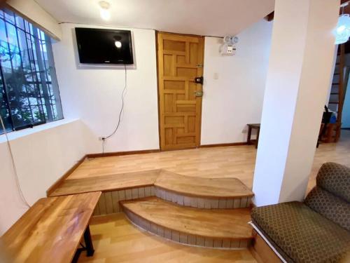 - un salon avec une table en bois et une télévision dans l'établissement Cusco departamento céntrico exclusivo, à Cusco