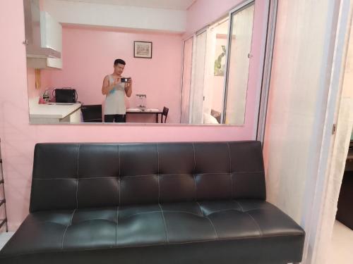 een persoon die een foto neemt in een spiegel in een kamer bij Azure Staycation by Yhiel in Manilla