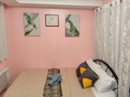 een slaapkamer met roze muren en een bed bij Azure Staycation by Yhiel in Manilla