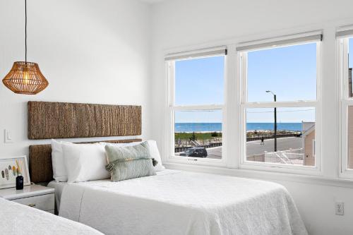 a white bedroom with two beds and a window at The Hideaway Hotel in Long Beach