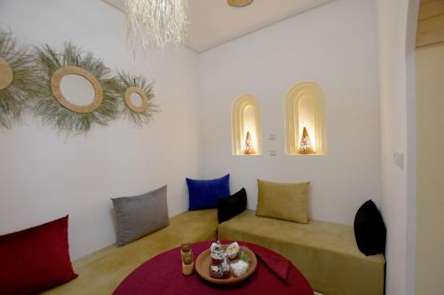 een woonkamer met een rode tafel en stoelen bij RIAD dreams dades in Tamellalt