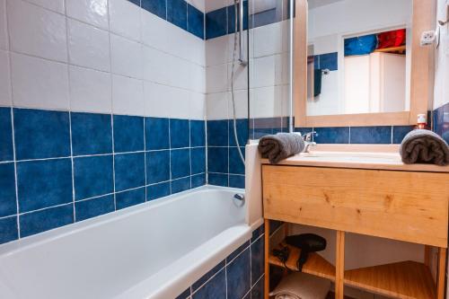 a bathroom with a tub and a sink and a mirror at Le studio de giens in Hyères