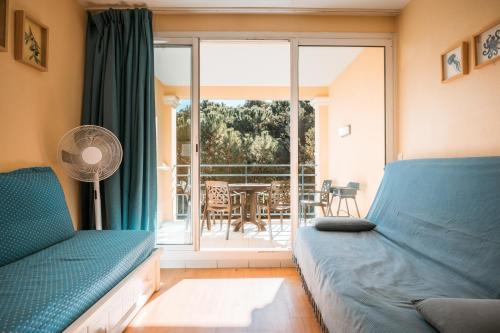 a room with a bed and a balcony with a table at Le studio de giens in Hyères