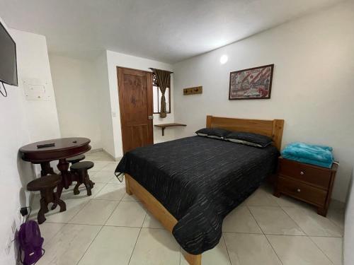 Schlafzimmer mit einem Bett, einem Tisch und einem Schreibtisch in der Unterkunft JericóHouse apto 202 in Jericó