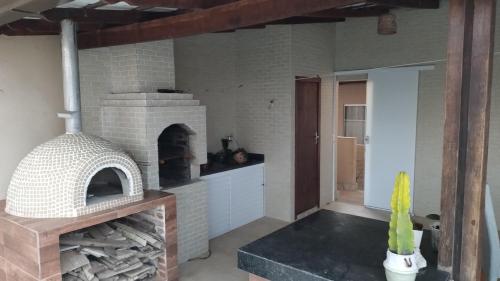 eine Küche mit einem Backsteinofen in einem Zimmer in der Unterkunft Casa de Praia in Fundão