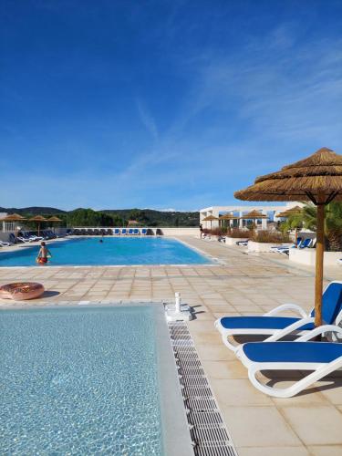 une piscine avec des chaises et un parasol dans l'établissement VILLA DE BELGODERE LOZARI, à Belgodère