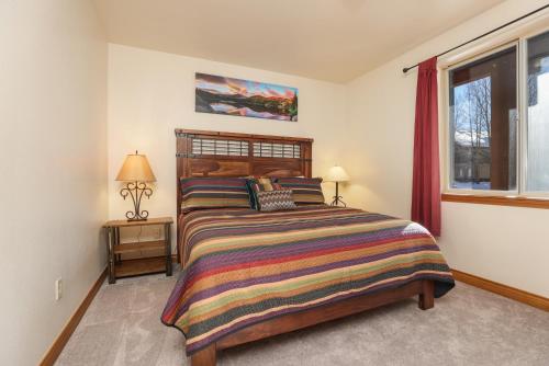 a bedroom with a large bed and a window at Retreat on the Blue Condo: Your Riverfront Retreat in Silverthorne