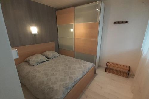 Dormitorio pequeño con cama y armario en Joli Appartement T2 avec Balcon "Le nid Libaud" en Chalon-sur-Saône