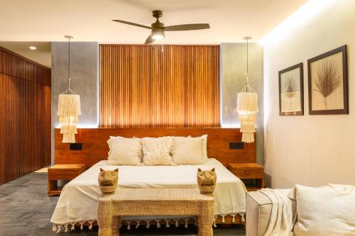 a bedroom with a bed with two cats sitting on it at 5 Star NEW Luxury Condo with Cenote and Infinity Pool in Tulum