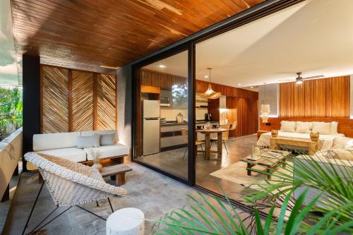 an open living room with glass walls and a kitchen at 5 Star NEW Luxury Condo with Cenote and Infinity Pool in Tulum