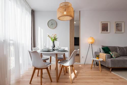 a living room with a dining room table and chairs at 9th Floor Wroclaw Business Apartment by Rentujemy in Wrocław