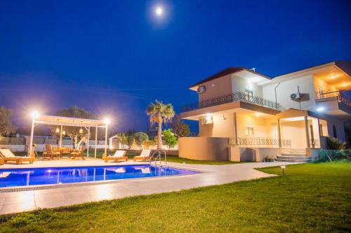 a large house with a swimming pool at night at Villa Cervus Dianae in Kallithea Rhodes
