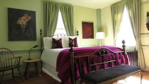 sypialnia z łóżkiem, krzesłem i oknami w obiekcie Eileen of Mystic w mieście Mystic
