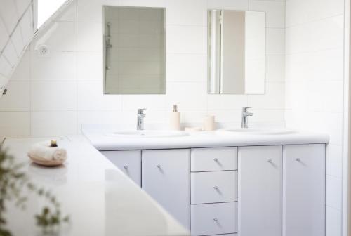a white bathroom with two sinks and a mirror at Le Rooftop Suresnes Paris La Défense - Spacieux Duplex 100 m2 Terrasse in Suresnes