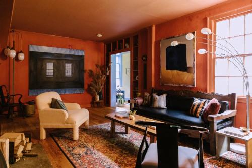 sala de estar con paredes de color naranja, sofá y mesa en Eileen of Mystic en Mystic