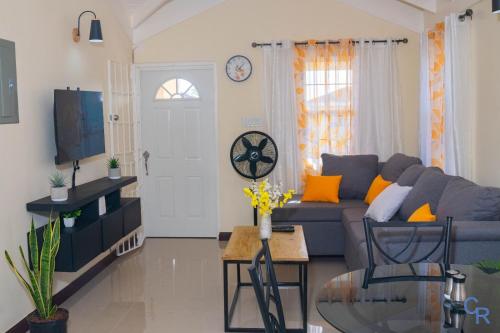 a living room with a blue couch and a tv at Charming refuge at Colbeck Manor in Old Harbour