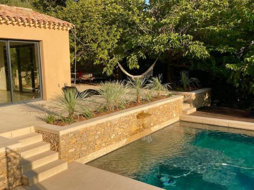 una piscina in un cortile con un muro di pietra di La villa Tamaris a Buis-les-Baronnies