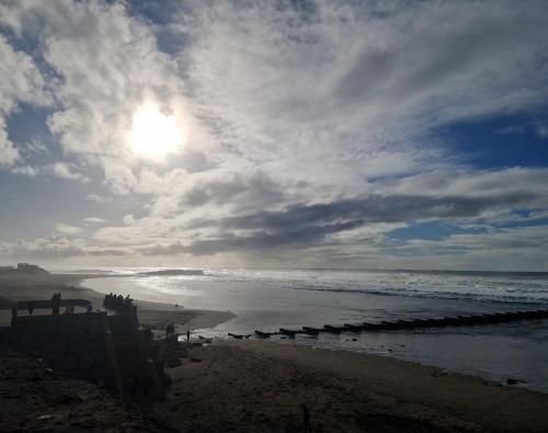 a beach with a cloudy sky and the ocean at Zenata ocean park appartement in Mohammedia