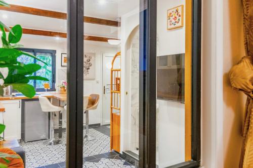 uma cozinha e sala de jantar com uma porta de vidro deslizante em Exquisite tiny house with garden and air con - between Paris-Disneyland - 3mins from train station em Noisy-le-Grand