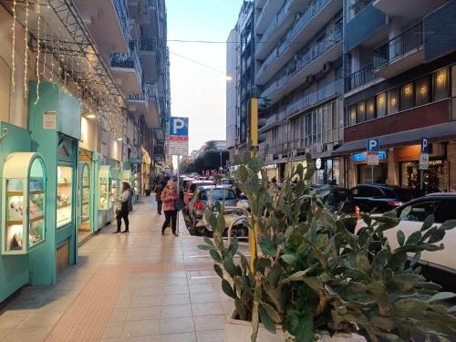 una calle de la ciudad con coches aparcados y gente caminando por la acera en APARTMENT ANDROMEDA, en Bari