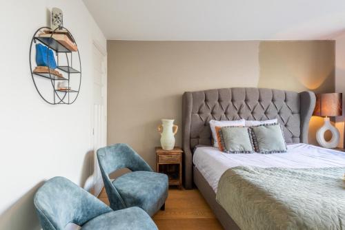 een slaapkamer met een bed en twee blauwe stoelen bij Big Room in Amsterdam