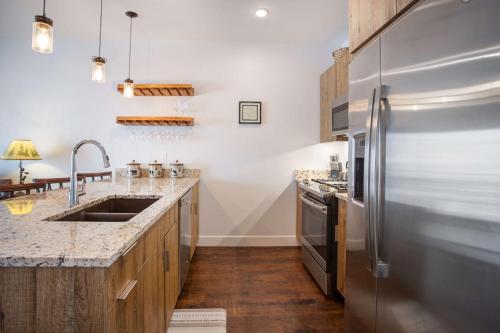 a kitchen with a stainless steel refrigerator and wooden cabinets at River West Buffalo Mountain Condo: On The Blue River in Silverthorne