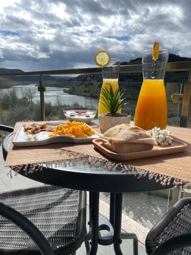 a table with food and orange juice on a patio at Douro Visit House in Torre de Moncorvo