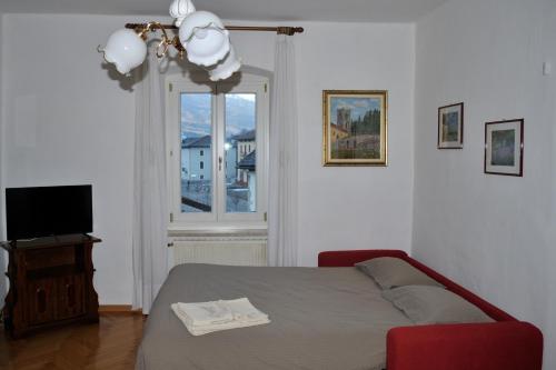 a bedroom with a bed and a television and a window at Incantevole appartamento in un Castello storico in Croviana