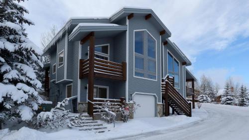 une maison bleue avec de la neige au sol dans l'établissement Deer Valley's Signature Collection, à Park City