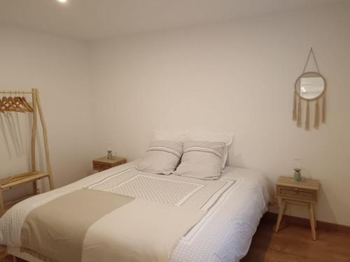 Dormitorio blanco con cama con sábanas y almohadas blancas en Au jardin Parisien en Argenteuil