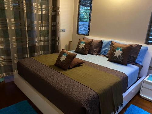 a bedroom with a bed with brown pillows at Villa Ora Na in Mahina