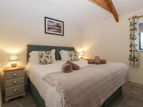 a bedroom with a large bed and a night stand at The Byre in Bridgend