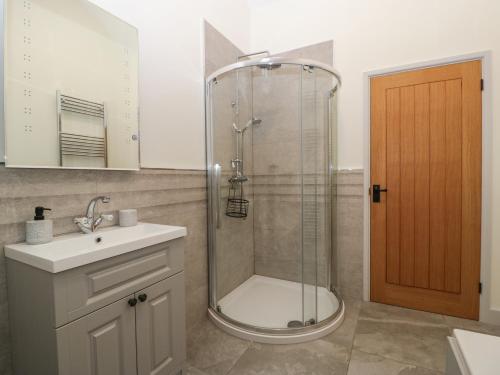 a bathroom with a shower and a toilet and a sink at The Byre in Bridgend