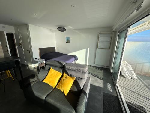 een woonkamer met een bank en gele kussens bij Studio face mer in La Baule