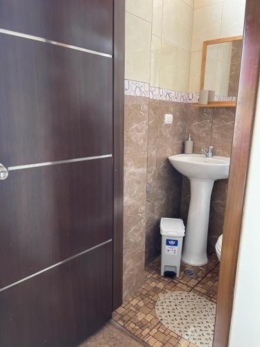 een badkamer met een wastafel, een toilet en een deur bij Kicker House Turtle Room in Puerto Baquerizo Moreno