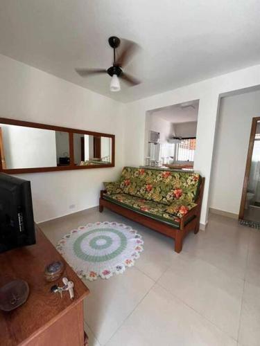 a living room with a couch and a ceiling fan at Condomínio Costa Azul in Caraguatatuba