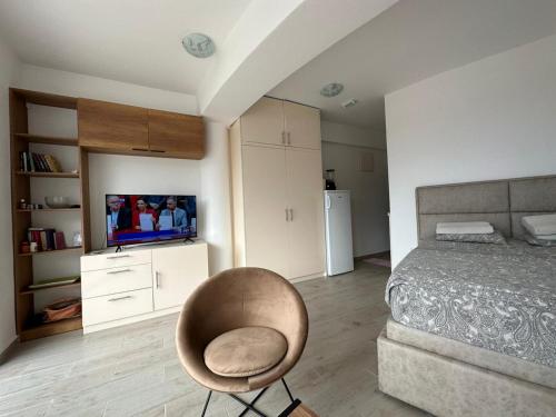 um quarto com uma cama, uma cadeira e uma televisão em Natali 3 em Sutomore
