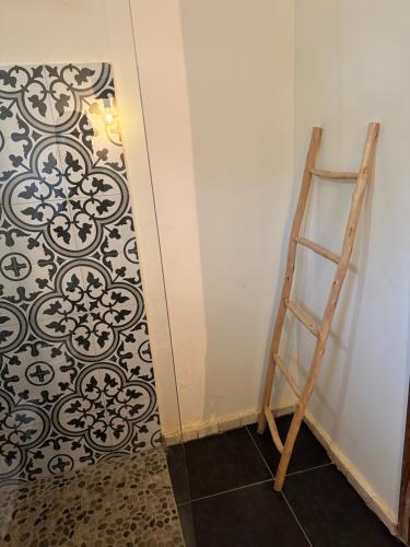 a ladder next to a wall with a black and white pattern at Le CavaLodge in Ngaparou