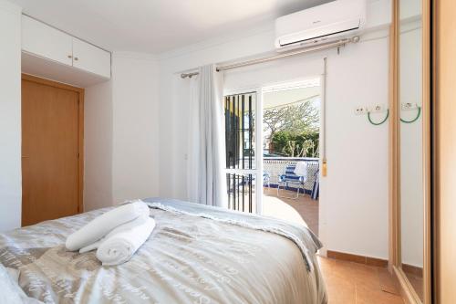 una camera da letto con un letto e asciugamani di BrisaMar II primera línea de playa & priv parking a Torre de Benagalbón