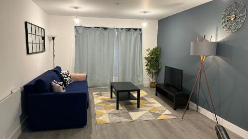 uma sala de estar com um sofá azul e uma televisão em Hemel Hives em Hemel Hempstead