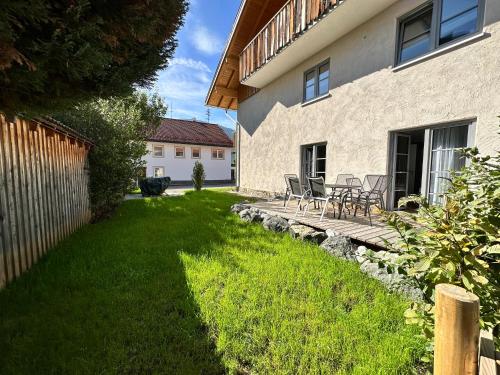 a yard with chairs and a table in a house at Ferienwohnungen WahlHeimat-Pfronten in Pfronten