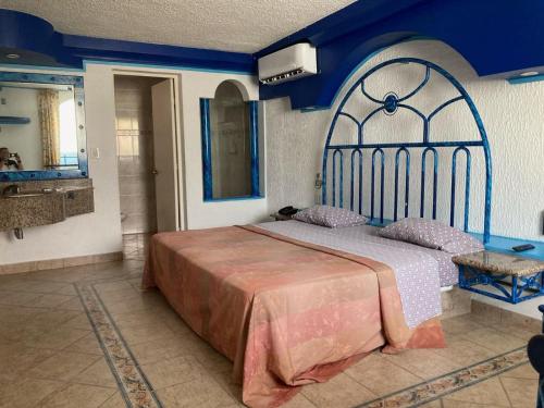 sypialnia z łóżkiem i niebieską ścianą w obiekcie Hotel Oasis Acapulco w Acapulco