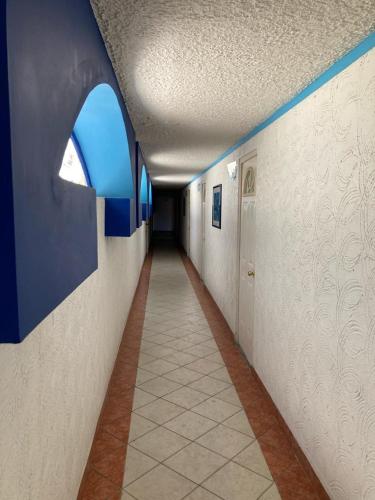 an empty hallway with a window in a building at Hotel Oasis Acapulco in Acapulco