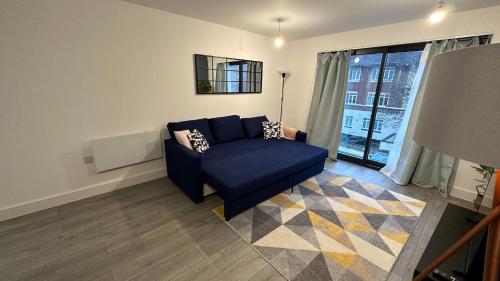 a living room with a blue couch and a window at Hemel Hives in Hemel Hempstead