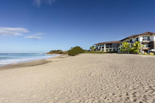 a view of the beach with condos in the background at JW Marriott Guanacaste Resort & Spa in Tamarindo
