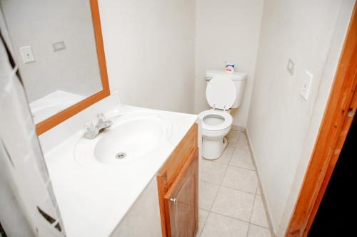 een badkamer met een witte wastafel en een toilet bij MOONLIGHT HOTEL BAR RESTO in Hinche