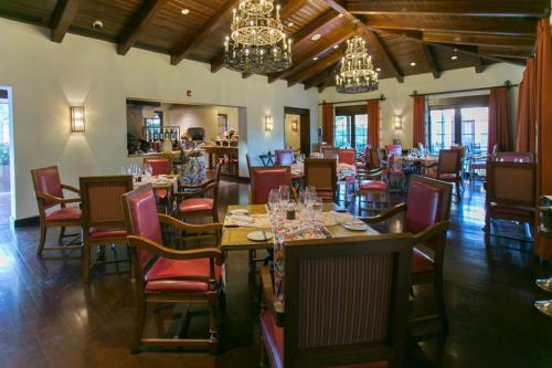 a dining room with tables and chairs and chandeliers at JW Marriott Guanacaste Resort & Spa in Tamarindo